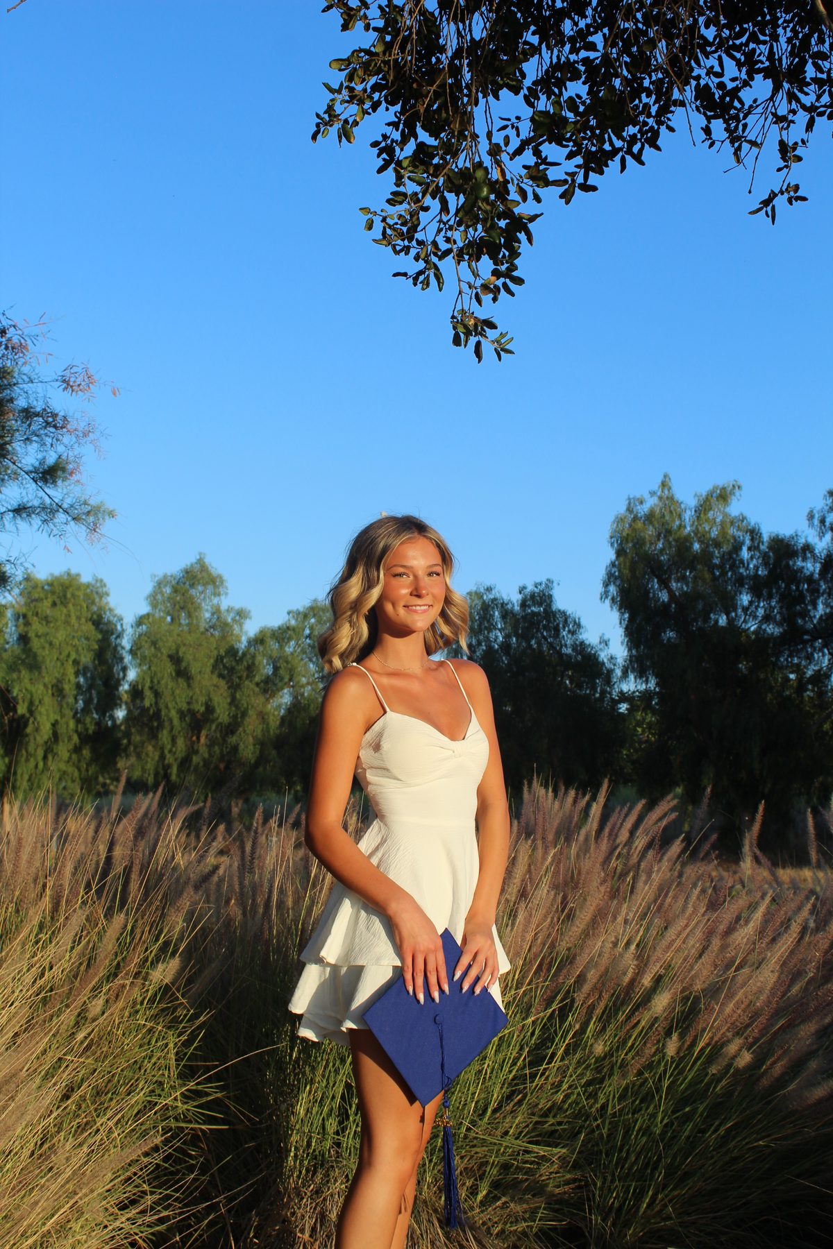 Graduation portrait — blue sky field